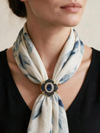 Close-up of the Midnight Flower Scarf Clasp worn with a blue-and-white scarf and black top